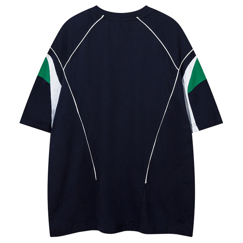 Oversized black paneled jersey tee with white contrast seams and green sleeve accents
