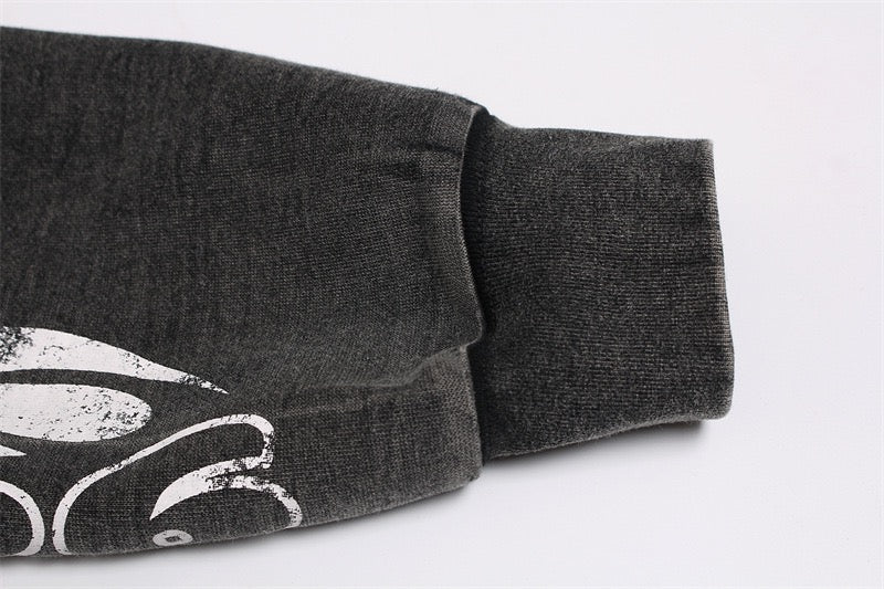 Close-up of dark gray hoodie sleeve cuff and graphic print