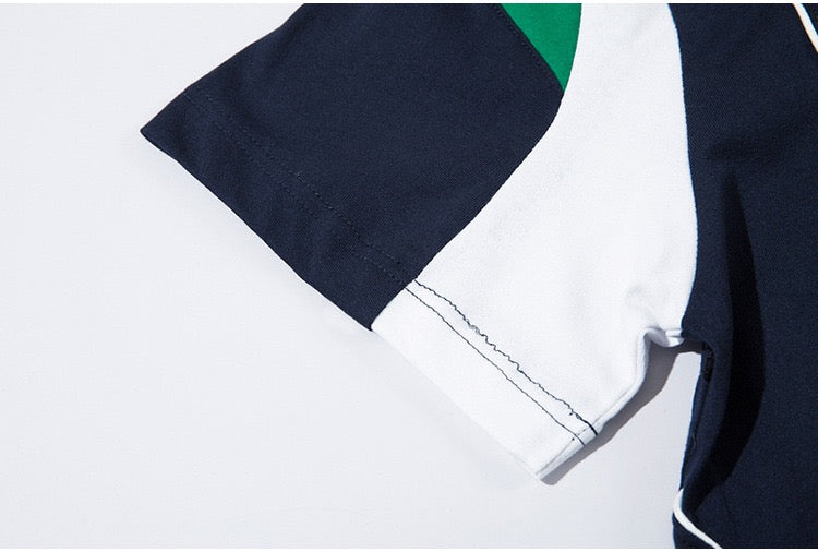 Oversized paneled jersey tee with navy, white, and green color blocks and visible contrast stitching on the sleeve
