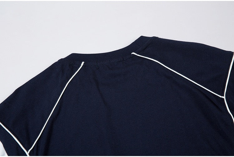 Navy oversized jersey tee with white piping and paneled raglan seams in a streetwear style