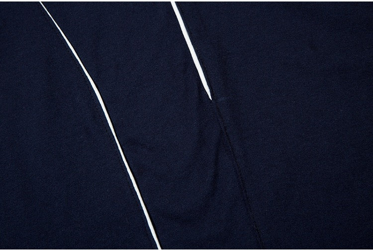 Close-up of a navy oversized jersey tee with white paneled seam lines and streetwear styling