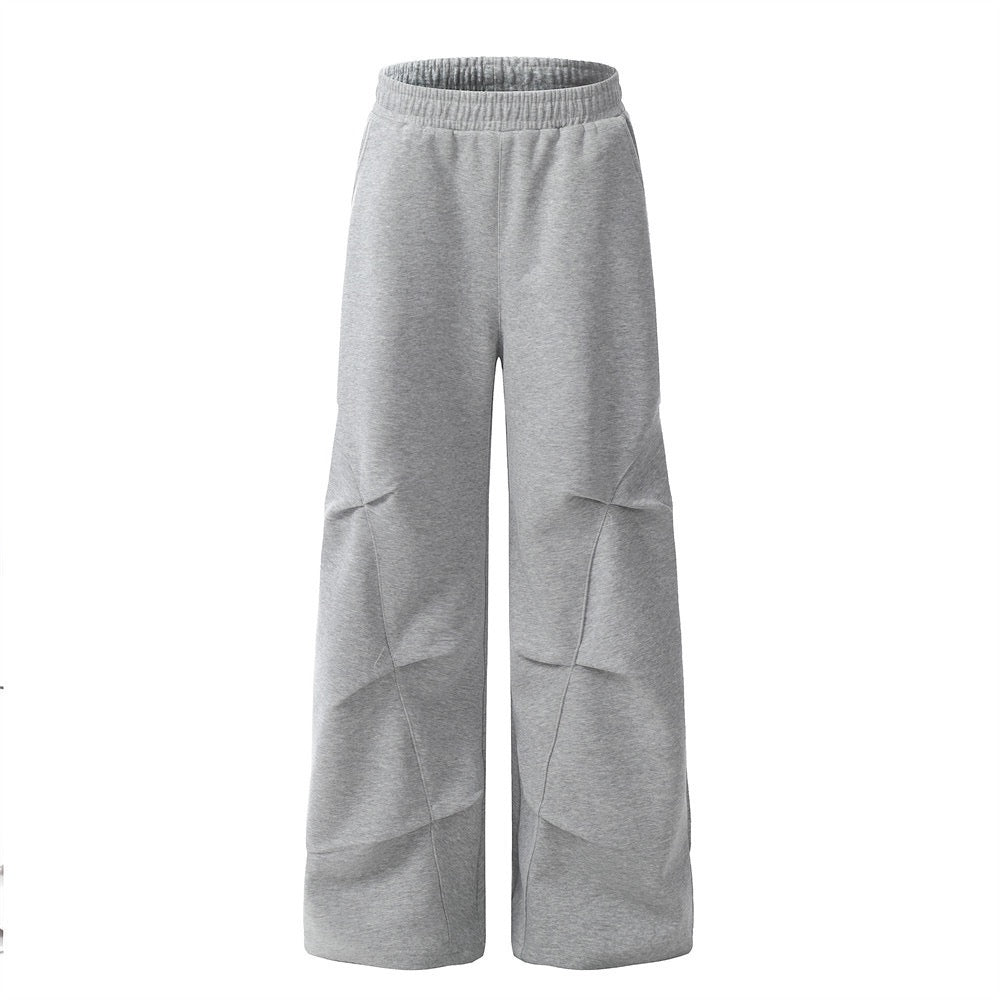 Front view of grey wide-leg sweatpants with sculpted seam lines and elastic waistband on white background