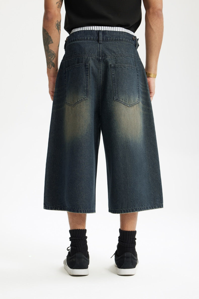 Back view close-up of wide-leg denim shorts with two back pockets and faded wash