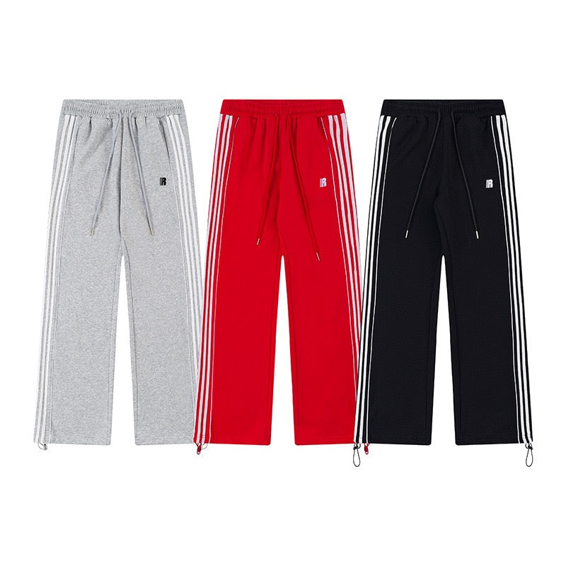 Heather gray triple-stripe track pants with white side stripes, drawstring waist, and adjustable hem on white background