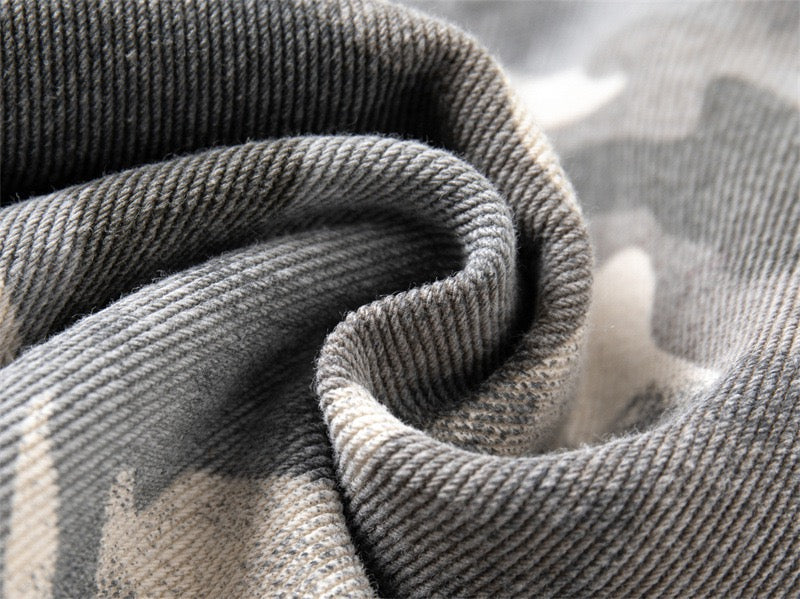 Close-up of gray camouflage denim fabric with visible twill weave