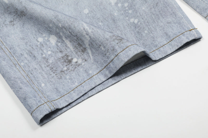 Close-up of lower leg hem on light wash denim shorts with faded denim wash
