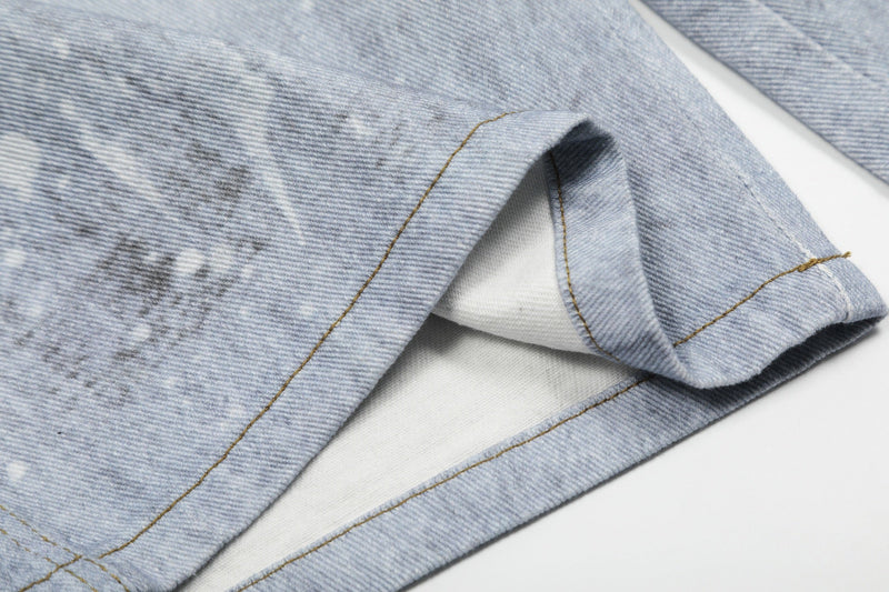 Close-up of hem and side seam on light wash denim shorts with folded cuff detail