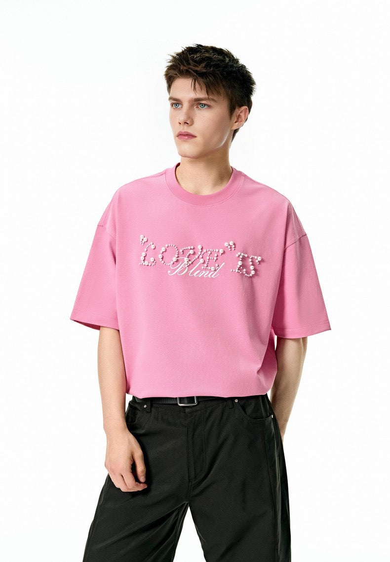 Pink oversized streetwear tee with pearl rhinestone Love Is Blind script on the chest