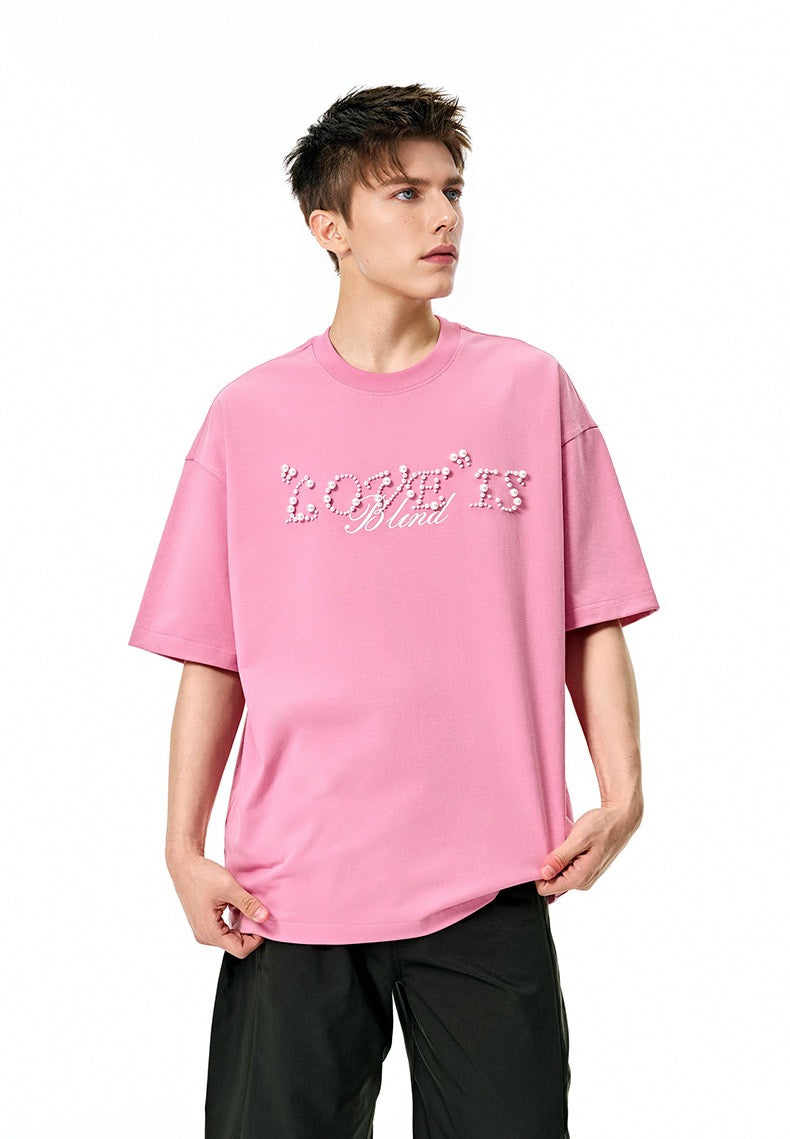 Pink oversized tee with pearl rhinestone Love Is Blind script on the chest and a relaxed streetwear fit