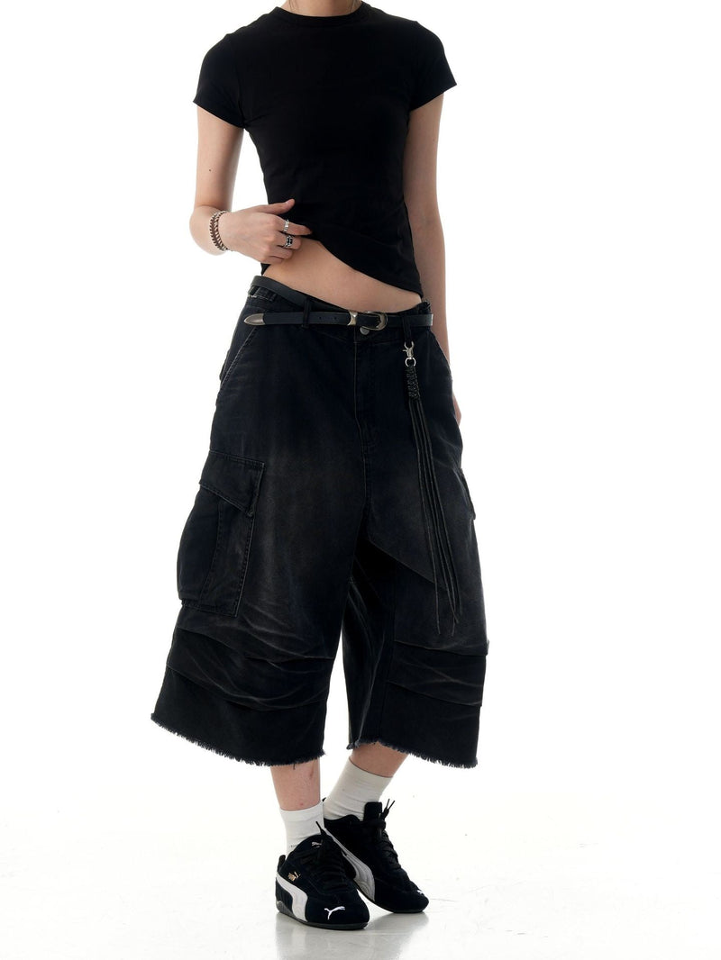 Black cargo shorts on model with side cargo pocket and layered panel hems, front view