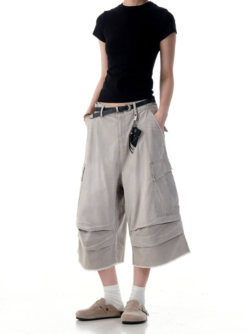 Beige cargo shorts on model with belt and hanging pouch, front view from waist to knee