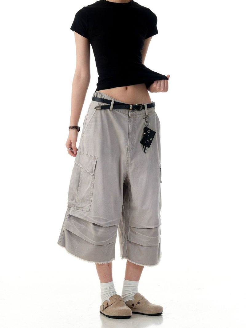 Beige cargo shorts on model with belt and hanging pouch, front view and wide-leg fit