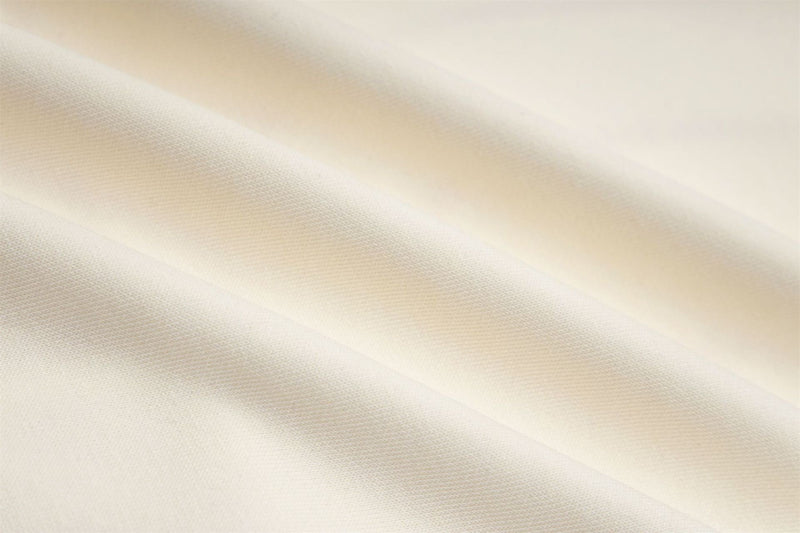 Close-up of cream hoodie fabric texture and diagonal folds