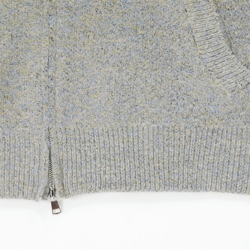 Close-up of light gray knit hem with front zipper and ribbed trim
