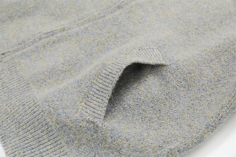 Close-up of light gray knit patch pocket on the jacket front