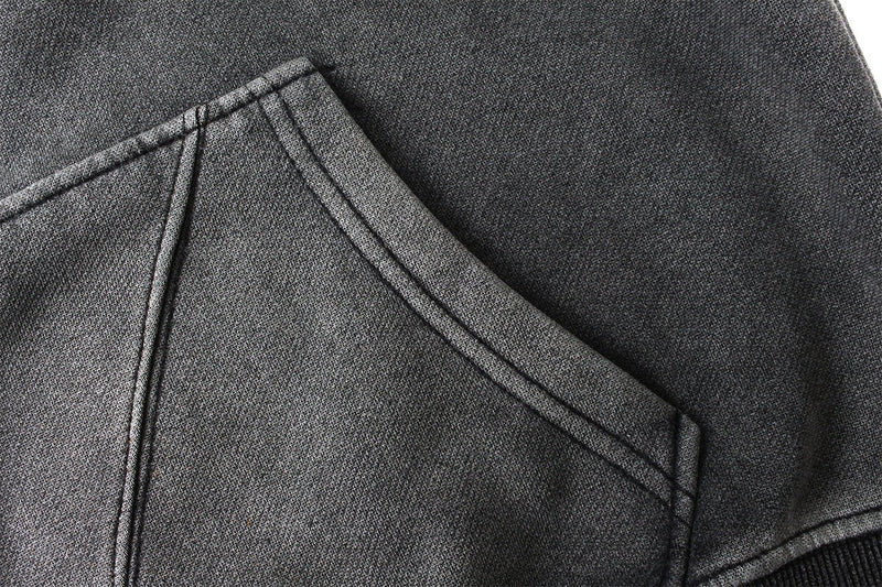 Close-up of a front chest panel and hood seam on a dark gray balaclava hoodie