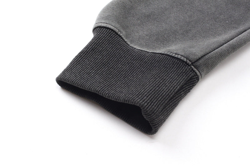 Close-up of a ribbed dark gray hoodie cuff with washed cotton texture