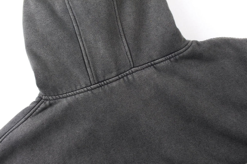 Close-up of the hood and shoulder seam on a dark gray washed cotton hoodie