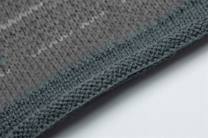 Close-up of ribbed sweater hem in gray and green knit