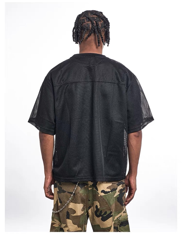 Black mesh football jersey with oversized fit, seen from the back on a model with camo cargo shorts