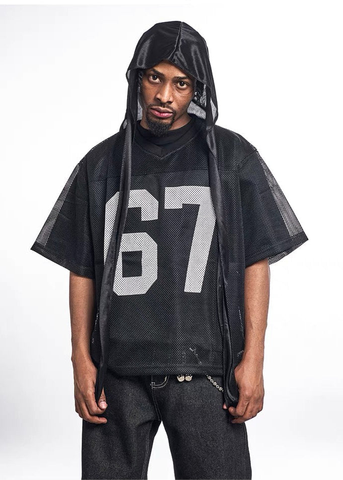 Black mesh jersey tee with large white 67 varsity number, worn over a hooded streetwear look