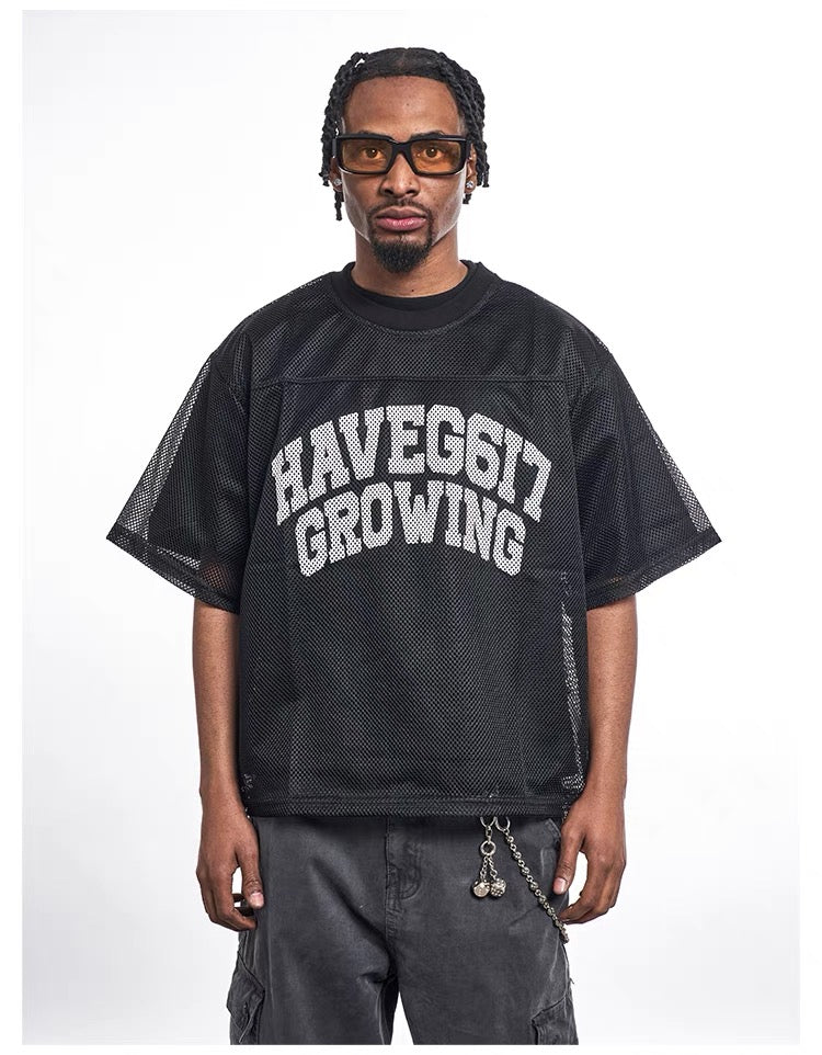 Black mesh jersey tee with oversized HAVEG617 GROWING graphic, styled on a model with streetwear cargo pants
