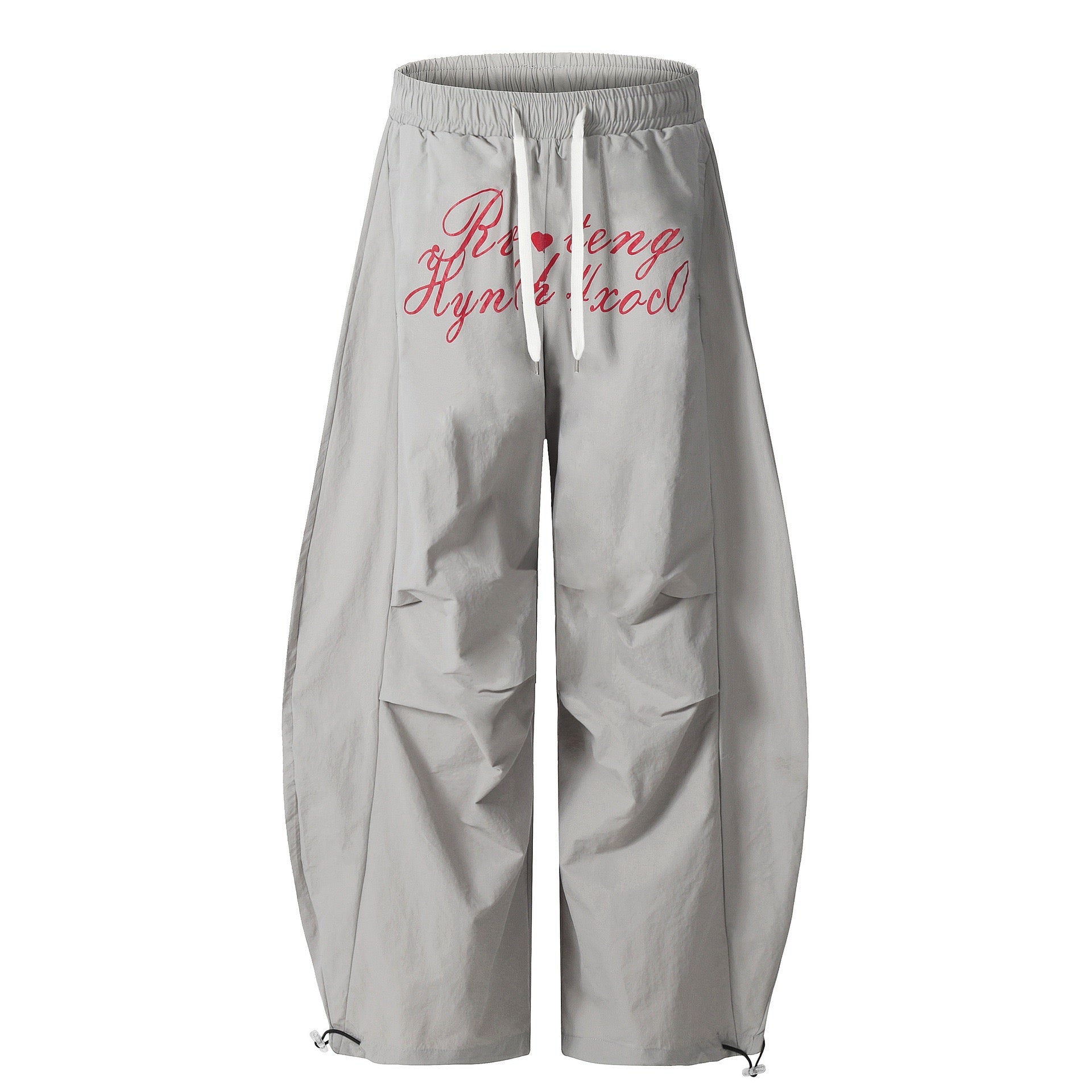 Light grey nylon wide-leg balloon pants with red handwritten script graphic print and white drawstring waistband, front view