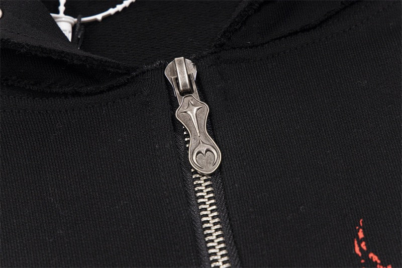 Close-up of black hoodie zipper pull with ornate metal detail