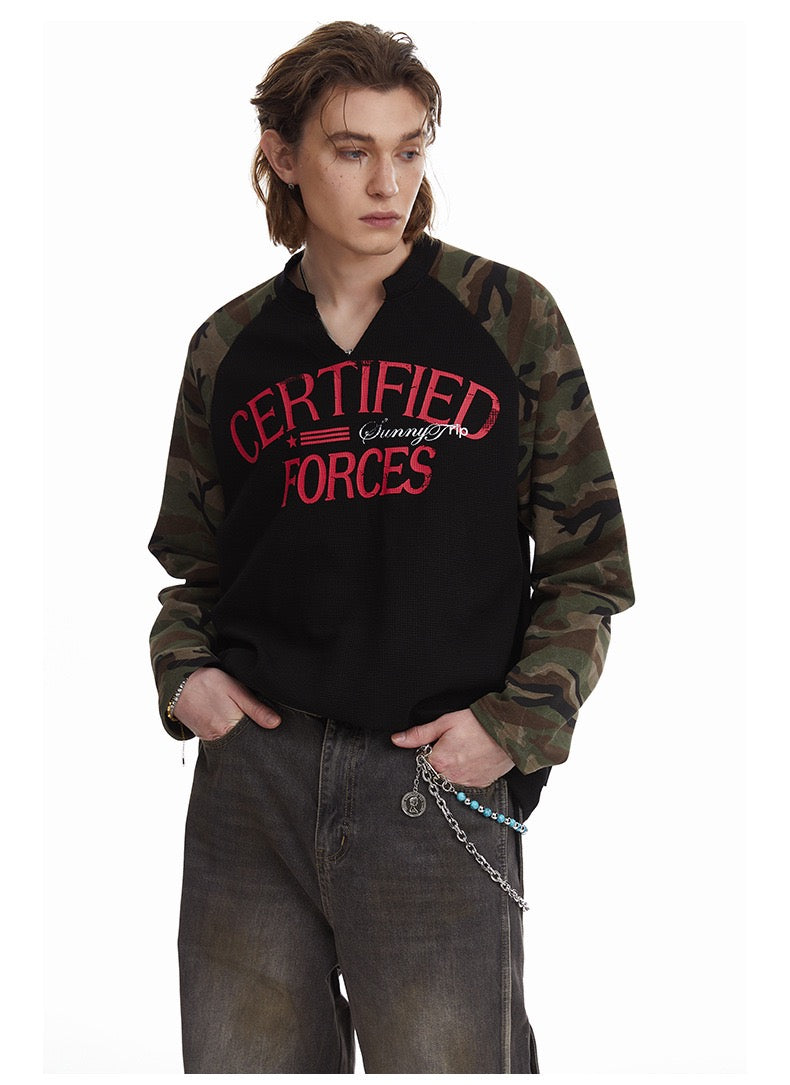 Model wearing black thermal raglan tee with camouflage sleeves and red Certified Forces print, cropped view