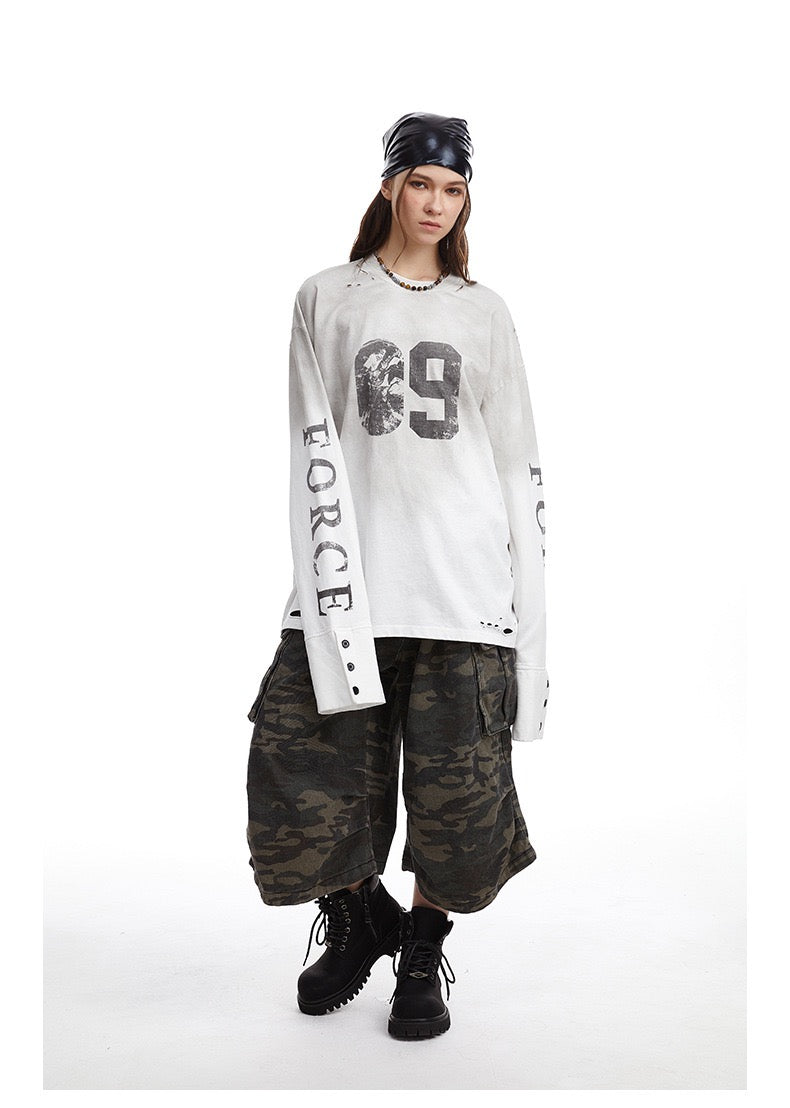 Cream distressed number 69 long-sleeve tee worn with sleeves showing button cuffs