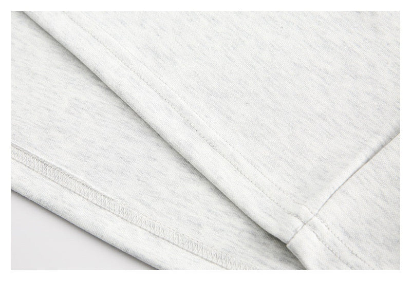 Close-up of sleeve cuff and stitching on light gray long sleeve tee