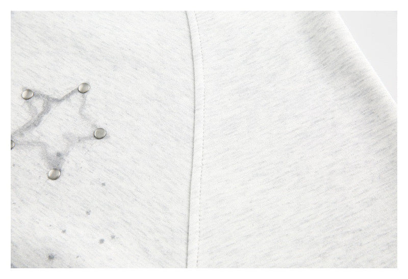 Close-up of front seam and star graphic detail on light gray tee