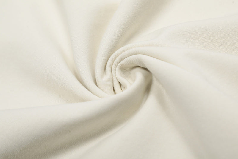 Close-up of cream knit fabric swirled to show texture
