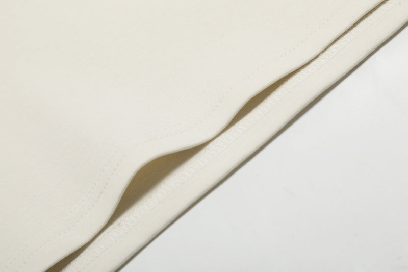 Close-up of cream fabric hem and stitching detail