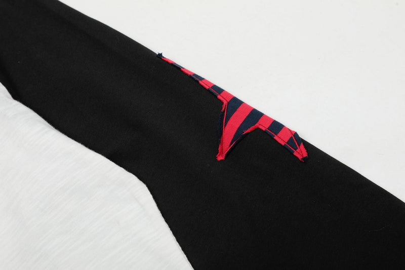 Close-up of black sleeve with red and navy striped star patch detail