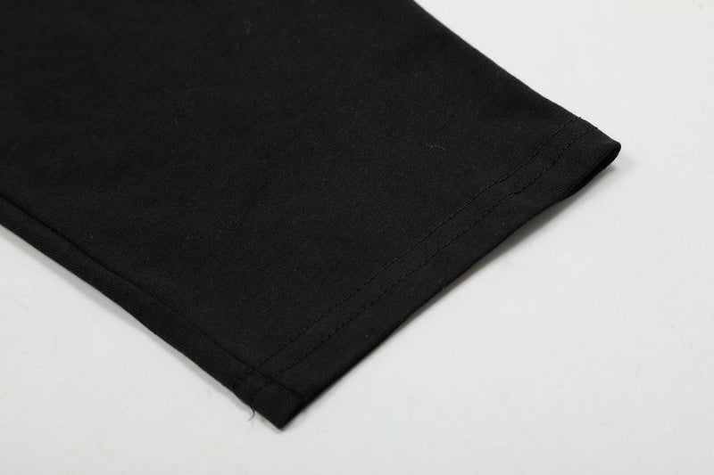 Close-up of black sleeve cuff and hem stitching on long-sleeve tee