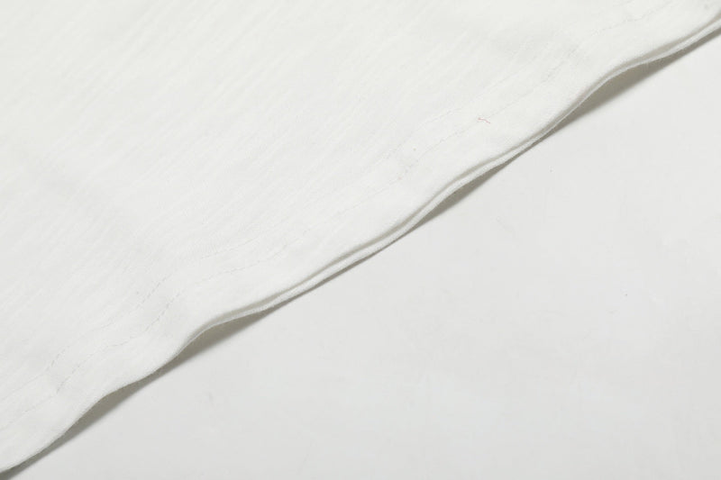 Close-up of white tee sleeve fabric and seam on raglan long-sleeve shirt