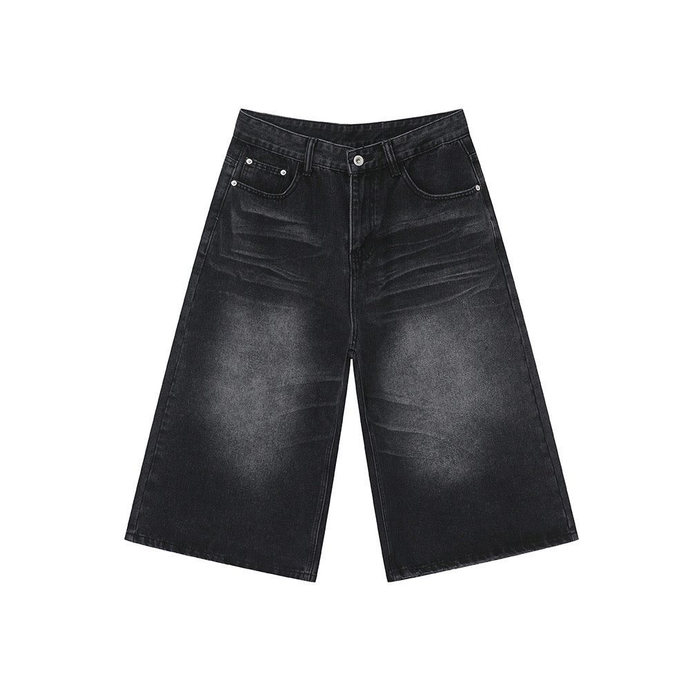 Flat lay of wide-leg washed black denim shorts with five-pocket construction and button closure