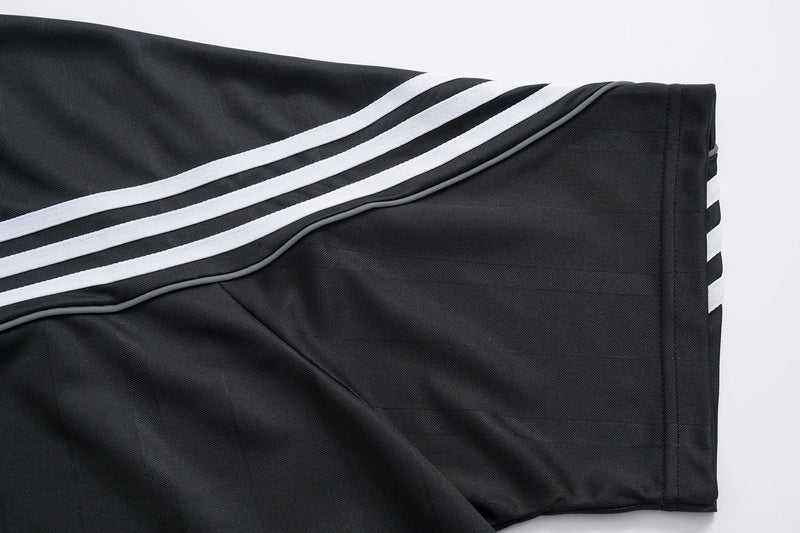 Black performance mesh athletic tee with three white stripes on the sleeve and side, shown in a close-up detail view