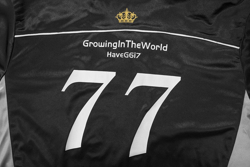 Close-up of black jersey back showing 77 print and crown logo near neckline