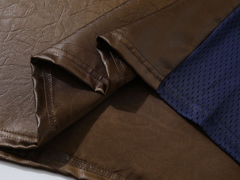 Close-up of a brown PU leather-look racing tee with stitched seams and blue mesh sleeve detail