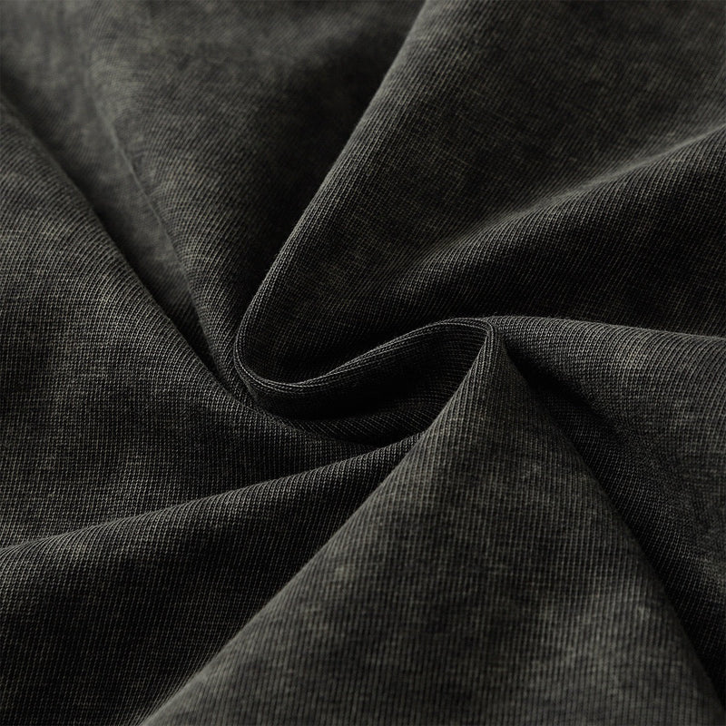 Close-up of washed black tee fabric with soft texture and draped folds