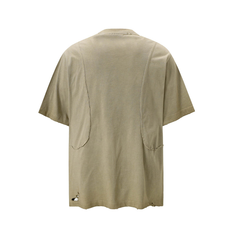 Beige distressed panel tee with visible seam details and worn hem on a washed cotton streetwear shirt