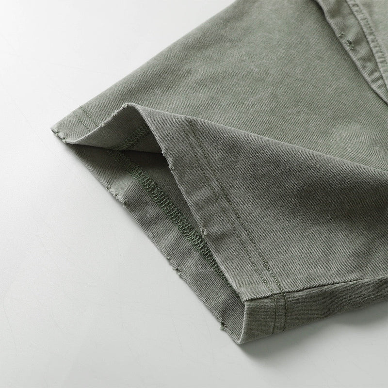 Close-up of washed olive green tee hem with distressed stitching and vintage panel detailing