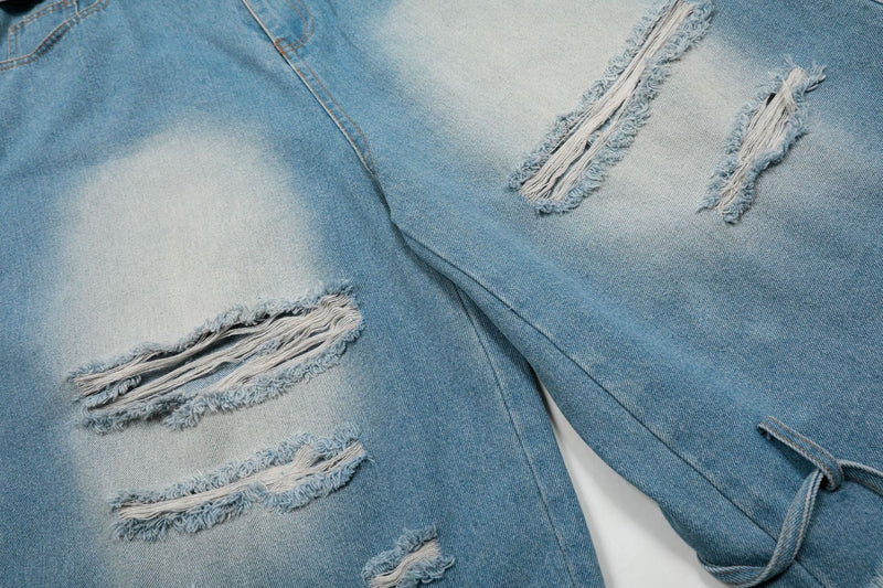 Close-up of distressed front legs on light wash denim jorts with ripped slits
