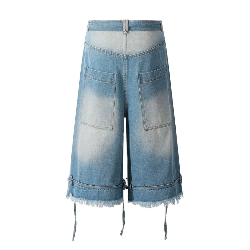 Back view of light wash wide-leg denim jorts with patch pockets and frayed hem