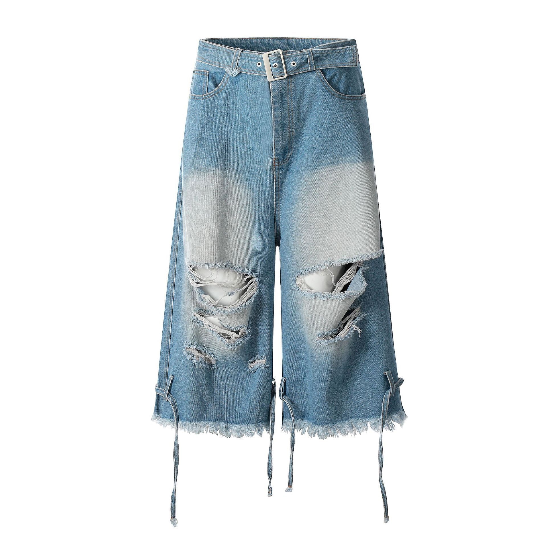 Front view of light blue wide-leg distressed denim jorts with built-in belt, ripped knees, and frayed hem tie straps