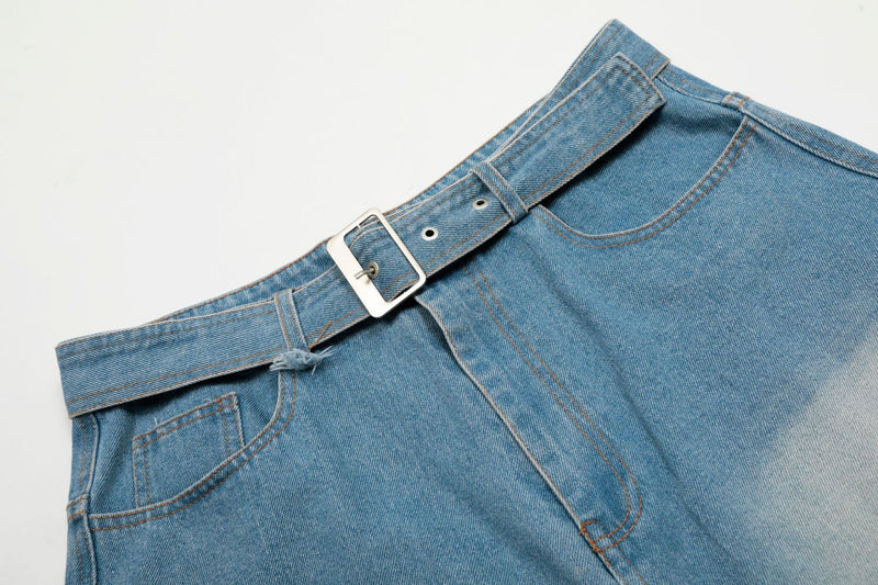 Waistband and front pocket detail of light wash denim jorts with silver buckle belt