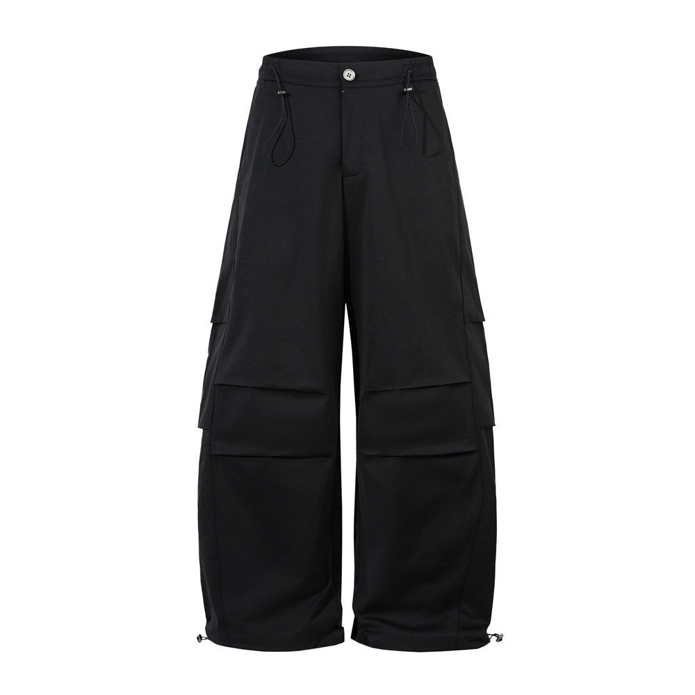 Black wide-leg cargo pants with layered pockets and adjustable drawcord waist, front view on white background