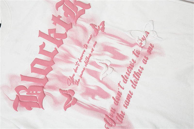White graphic tee with pink gothic lettering, butterfly accents, and a distressed dark romantic streetwear print